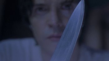 Movie still from “Hellraiser: Deader” (2005), directed by Rick Bota – A person holding a large knife in front of their face; Extreme Close Up shot, Low angle