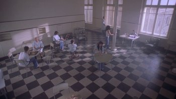 Movie still from “Hellraiser: Deader” (2005), directed by Rick Bota – A group of people sitting at a table in a room; Extreme Wide shot, High angle