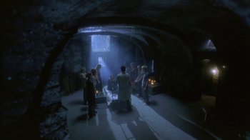 Movie still from “Hellraiser: Deader” (2005), directed by Rick Bota – A group of people standing around in a cave; Wide shot, High angle