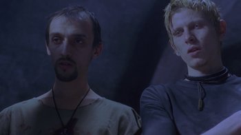 Movie still from “Hellraiser: Deader” (2005), directed by Rick Bota – Two men standing next to each other in front of a dark background; Close Up shot, Low angle