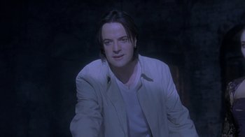 Movie still from “Hellraiser: Deader” (2005), directed by Rick Bota – A man with long black hair sitting in a dark room; Close Up shot, Low angle