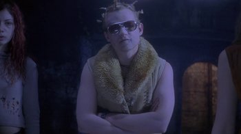 Movie still from “Hellraiser: Deader” (2005), directed by Rick Bota – A man wearing sunglasses and a furry collar; Medium shot, Low angle