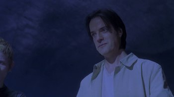 Movie still from “Hellraiser: Deader” (2005), directed by Rick Bota – A man with long black hair standing in front of a cloudy sky; Close Up shot, Low angle