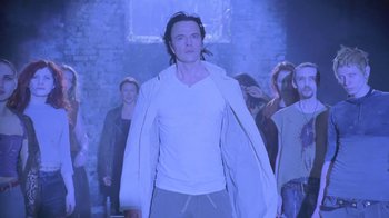 Movie still from “Hellraiser: Deader” (2005), directed by Rick Bota – A group of people standing around a man in a white shirt; Medium shot, Low angle