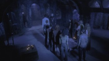Movie still from “Hellraiser: Deader” (2005), directed by Rick Bota – A group of people standing in a dark room; Wide shot, High angle