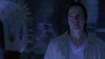 Movie still from “Hellraiser: Deader” (2005), directed by Rick Bota – A man standing in the dark looking up at the ceiling; Close Up shot, Over the shoulder angle