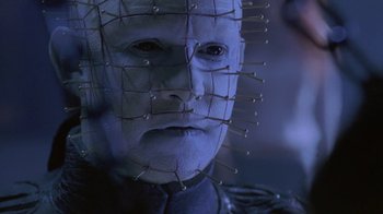 Movie still from “Hellraiser: Deader” (2005), directed by Rick Bota – A person with a face covered in pins; Close Up shot, Low angle