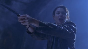 Movie still from “Hellraiser: Deader” (2005), directed by Rick Bota – A woman holding a gun in her hand; Medium shot, Low angle