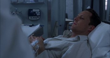 Movie still from “Hellraiser: Hellseeker” (2002), directed by Rick Bota – A man laying in a hospital bed holding a cell phone; Medium shot, High angle
