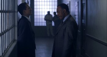 Movie still from “Hellraiser: Hellseeker” (2002), directed by Rick Bota – Two men in business suits talking in a building; Medium shot, Over the shoulder angle