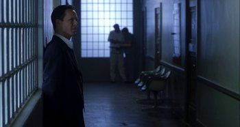 Movie still from “Hellraiser: Hellseeker” (2002), directed by Rick Bota – A man in a suit and tie standing in front of a window; Medium shot, Over the shoulder angle