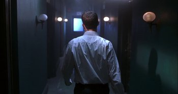 Movie still from “Hellraiser: Hellseeker” (2002), directed by Rick Bota – A man walking down a hallway in a dark room; Medium shot, Low angle