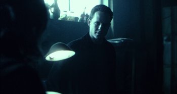 Movie still from “Hellraiser: Hellseeker” (2002), directed by Rick Bota – A man standing in a room with a light on; Close Up shot, Over the shoulder angle