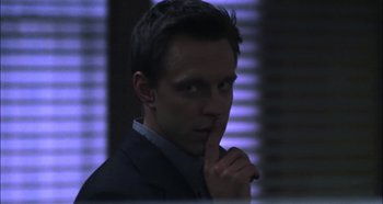 Movie still from “Hellraiser: Hellseeker” (2002), directed by Rick Bota – A man in a black suit is holding his finger to his mouth; Close Up shot, Over the shoulder angle