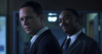 Movie still from “Hellraiser: Hellseeker” (2002), directed by Rick Bota – A man in a suit and tie standing next to another man in a suit and tie; Close Up shot, Low angle