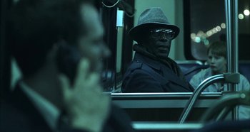 Movie still from “Hellraiser: Hellseeker” (2002), directed by Rick Bota – A man in a hat and glasses sitting on a bus; Medium shot, Over the shoulder angle
