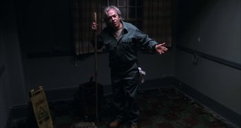 Movie still from “Hellraiser: Hellseeker” (2002), directed by Rick Bota – An old man holding a wooden stick in a room; Medium shot, Low angle