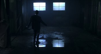 Movie still from “Hellraiser: Hellseeker” (2002), directed by Rick Bota – A man standing in the dark in front of two large windows; Wide shot, Low angle