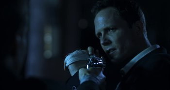 Movie still from “Hellraiser: Hellseeker” (2002), directed by Rick Bota – A man in a suit and tie holding a gun; Close Up shot, Low angle