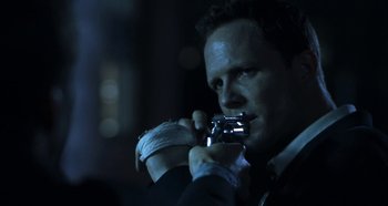 Movie still from “Hellraiser: Hellseeker” (2002), directed by Rick Bota – A man in a black suit holding a camera; Close Up shot, Over the shoulder angle