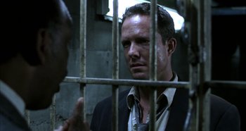 Movie still from “Hellraiser: Hellseeker” (2002), directed by Rick Bota – A man standing next to another man in a jail cell; Close Up shot, Over the shoulder angle