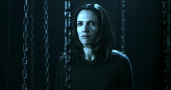 Movie still from “Hellraiser: Hellseeker” (2002), directed by Rick Bota – A woman standing in front of chains in a dark room; Medium shot, Low angle