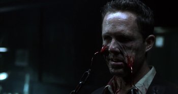 Movie still from “Hellraiser: Hellseeker” (2002), directed by Rick Bota – A man with blood on his face and a chain around his neck; Close Up shot, Over the shoulder angle