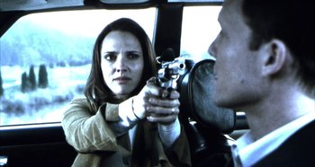 Movie still from “Hellraiser: Hellseeker” (2002), directed by Rick Bota – A woman holding a gun pointed at a man in a car; Close Up shot, Over the shoulder angle