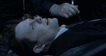 Movie still from “Hellraiser: Hellseeker” (2002), directed by Rick Bota – A man in a black suit is laying on the ground; Close Up shot, High angle