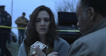 Movie still from “Hellraiser: Hellseeker” (2002), directed by Rick Bota – A woman sitting down holding a card; Close Up shot, Over the shoulder angle
