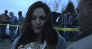 Movie still from “Hellraiser: Hellseeker” (2002), directed by Rick Bota – A woman holding an alarm clock while standing in front of a crowd of onlookers; Close Up shot, Over the shoulder angle