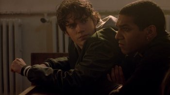 Movie still from “Hellraiser: Hellworld” (2005), directed by Rick Bota – Two young men sitting next to each other on a couch; Close Up shot, Over the shoulder angle