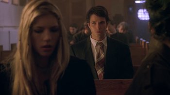 Movie still from “Hellraiser: Hellworld” (2005), directed by Rick Bota – A man in a suit standing next to a woman in a black suit; Medium shot, Over the shoulder angle