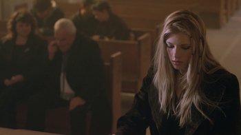 Movie still from “Hellraiser: Hellworld” (2005), directed by Rick Bota – A woman sitting at a table in front of other people; Medium shot, Low angle