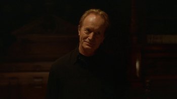 Movie still from “Hellraiser: Hellworld” (2005), directed by Rick Bota – A man in a black shirt is standing in the dark; Close Up shot, Low angle