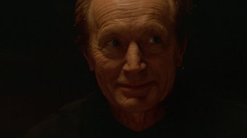 Movie still from “Hellraiser: Hellworld” (2005), directed by Rick Bota – An old man with a black shirt and a black background; Close Up shot, Low angle