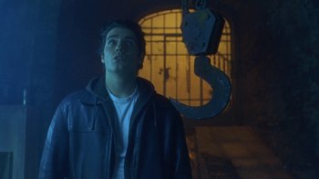 Movie still from “Hellraiser: Hellworld” (2005), directed by Rick Bota – A man standing in front of a chain hanging from the ceiling; Medium shot, Low angle