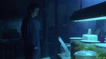 Movie still from “Hellraiser: Hellworld” (2005), directed by Rick Bota – A man standing in front of a table filled with food; Medium shot, Low angle