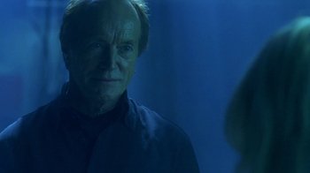 Movie still from “Hellraiser: Hellworld” (2005), directed by Rick Bota – An older man is looking at the camera in the dark; Close Up shot, Over the shoulder angle