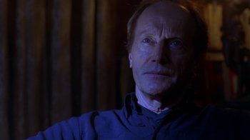 Movie still from “Hellraiser: Hellworld” (2005), directed by Rick Bota – An older man with a beard and a blue shirt; Close Up shot, Over the shoulder angle