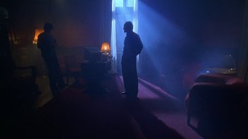 Movie still from “Hellraiser: Hellworld” (2005), directed by Rick Bota – A man standing in a room in front of a window; Wide shot, Low angle