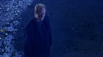 Movie still from “Hellraiser: Hellworld” (2005), directed by Rick Bota – A man standing in the dark looking at the camera; Medium shot, Low angle