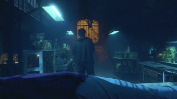 Movie still from “Hellraiser: Hellworld” (2005), directed by Rick Bota – A man standing in a dark room next to a window; Wide shot, Low angle