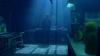 Movie still from “Hellraiser: Hellworld” (2005), directed by Rick Bota – A man standing in a room with a bed in the middle of the floor; Wide shot, Low angle