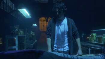 Movie still from “Hellraiser: Hellworld” (2005), directed by Rick Bota – A man standing in front of an ironing board in a dark room; Medium shot, Low angle