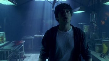 Movie still from “Hellraiser: Hellworld” (2005), directed by Rick Bota – A young man standing in a dark room; Medium shot, Low angle