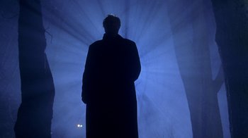 Movie still from “Hellraiser: Hellworld” (2005), directed by Rick Bota – A man standing in front of a blue light; Wide shot, Low angle