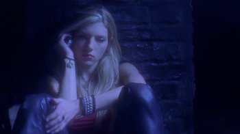 Movie still from “Hellraiser: Hellworld” (2005), directed by Rick Bota – A beautiful young lady sitting on the ground in front of a brick wall; Medium shot, Low angle