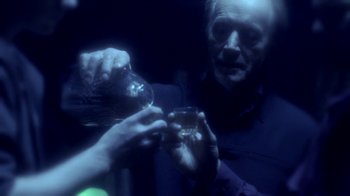Movie still from “Hellraiser: Hellworld” (2005), directed by Rick Bota – A man holding a wine glass in his hands; Close Up shot, Over the shoulder angle