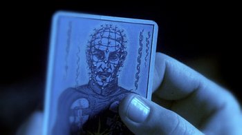 Movie still from “Hellraiser: Hellworld” (2005), directed by Rick Bota – A hand holding a piece of paper with a drawing of a man's head; Extreme Close Up shot, Overhead angle